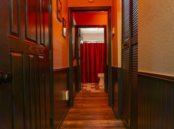 Hallway with black wainscoting and red light