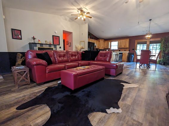 Living room with red leather sectional and cowhide rug