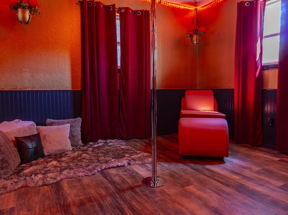 Performance pole, red chaise and faux fur rug in the Pole Lounge