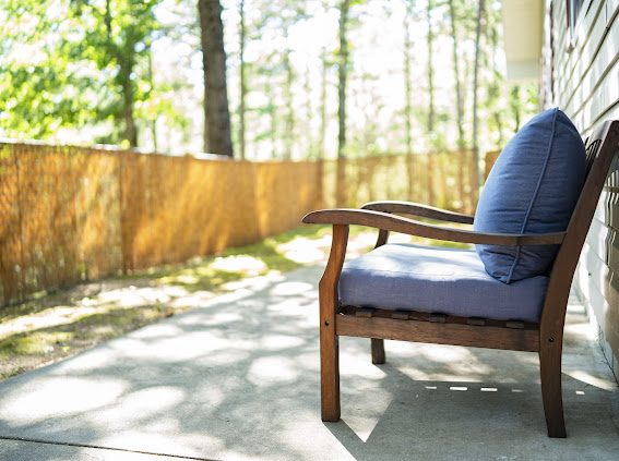 Shaded side patio with privacy fence and trees